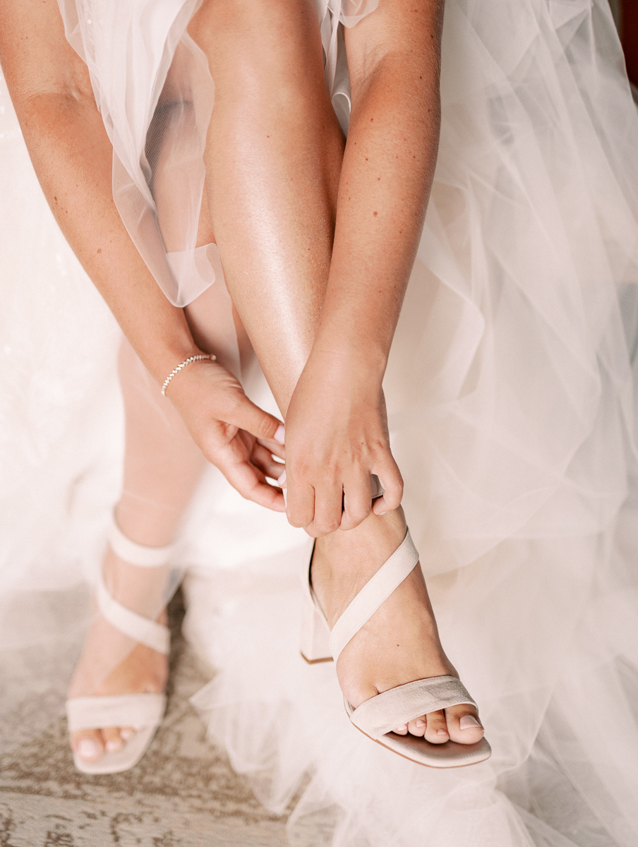 bruid trekt haar trouwschoenen aan